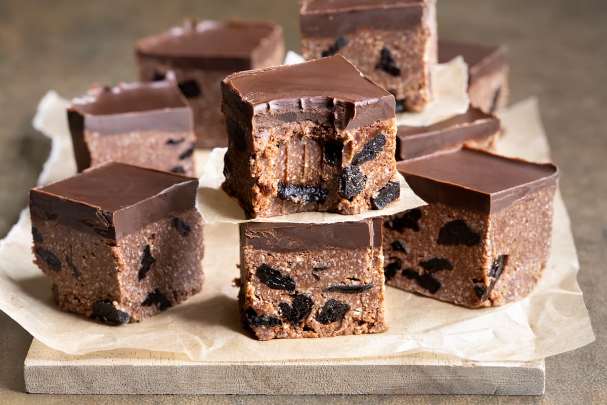 Pieces of vegan chocolate sour cherry slice on a wooden board