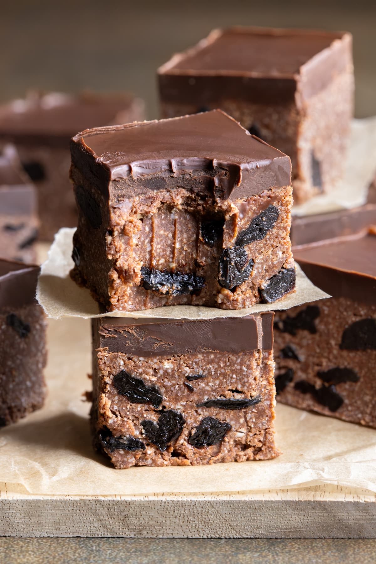 Stacked pieces of chocolate sour cherry slice with a bite taken out of one piece