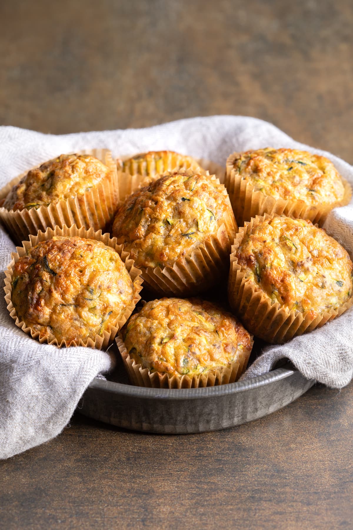 Buckwheat zucchini muffins in a tin lined with a tea towel