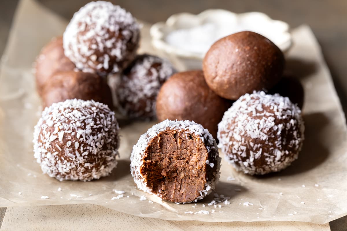 Homemade choc mint protein balls coated in coconut on a wooden board