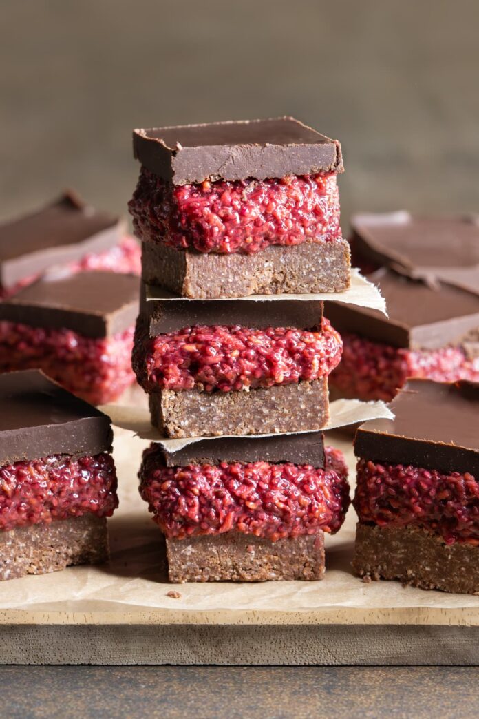 Pieces of vegan chocolate raspberry chia slice stacked on top of each other