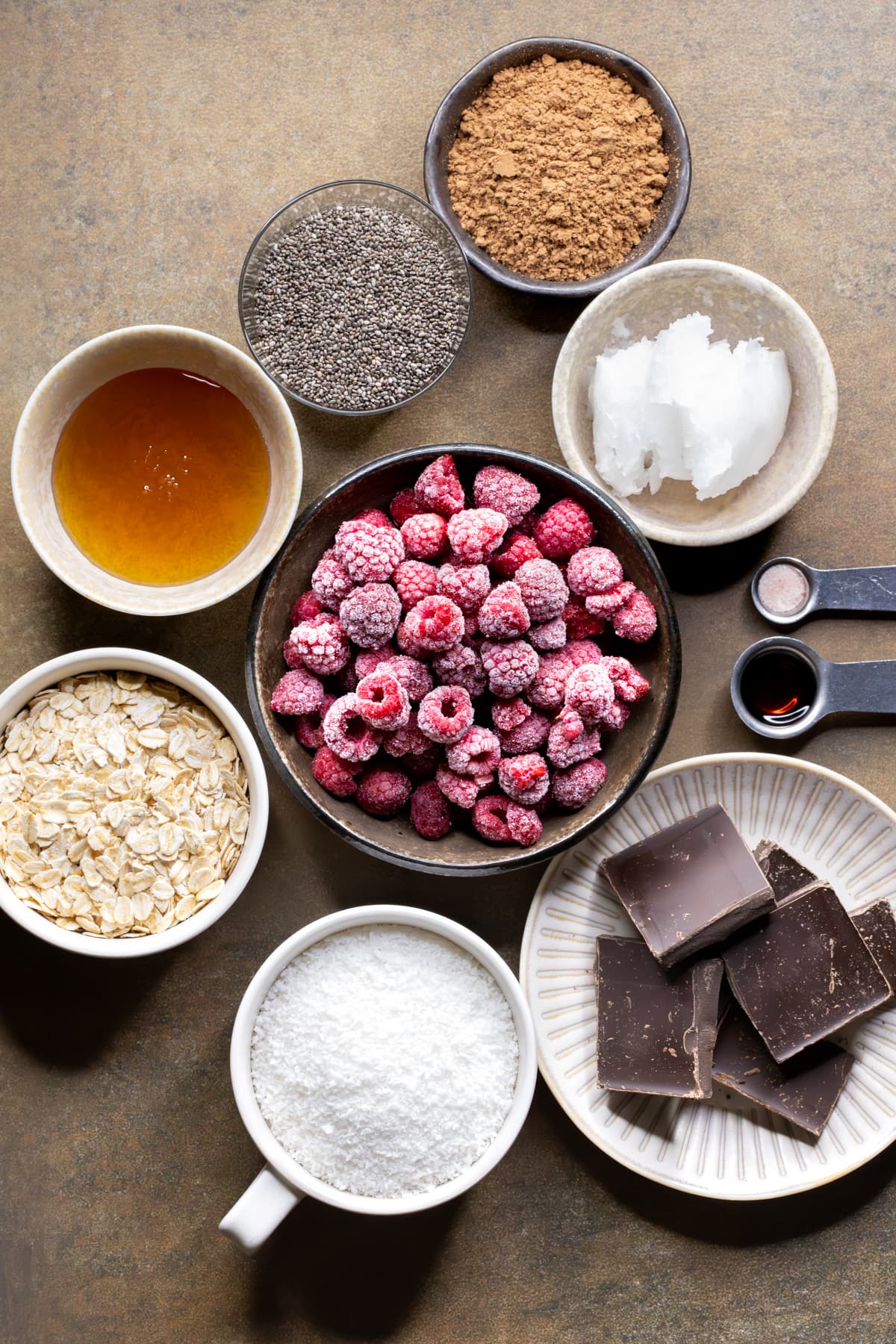 Ingredients for chocolate raspberry chia slice separated into bowls