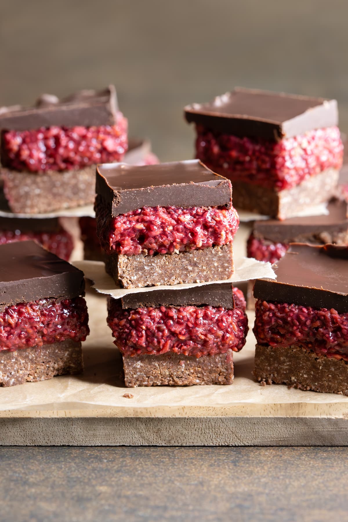 Two pieces of no-bake chocolate raspberry chia slice separated by baking paper