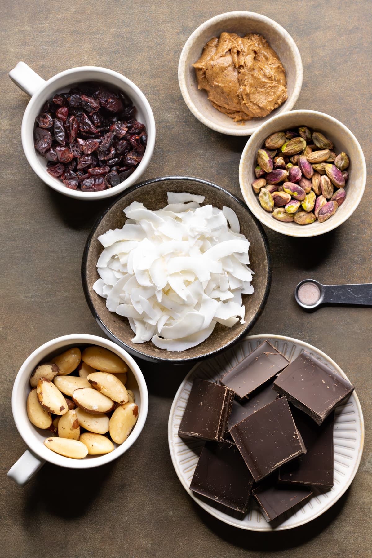 Ingredients for healthy rocky road set out in small bowls and mugs