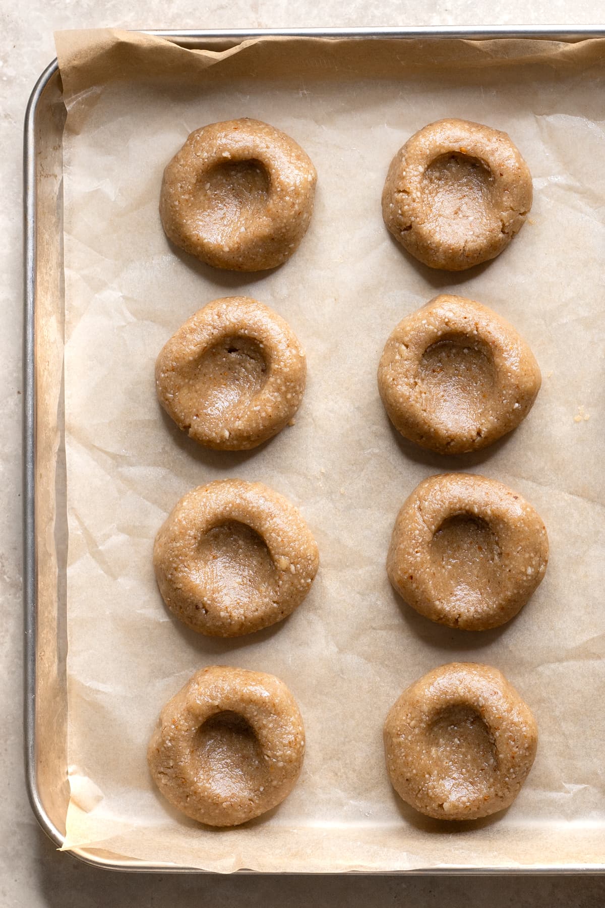 Dough for buckwheat jam thumbprint cookies on a baking tray