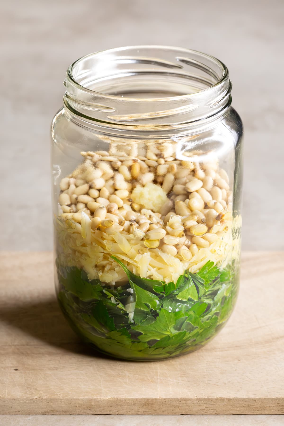 Ingredients for parsley pine nut pesto in a wide mouth jar ready to be blended