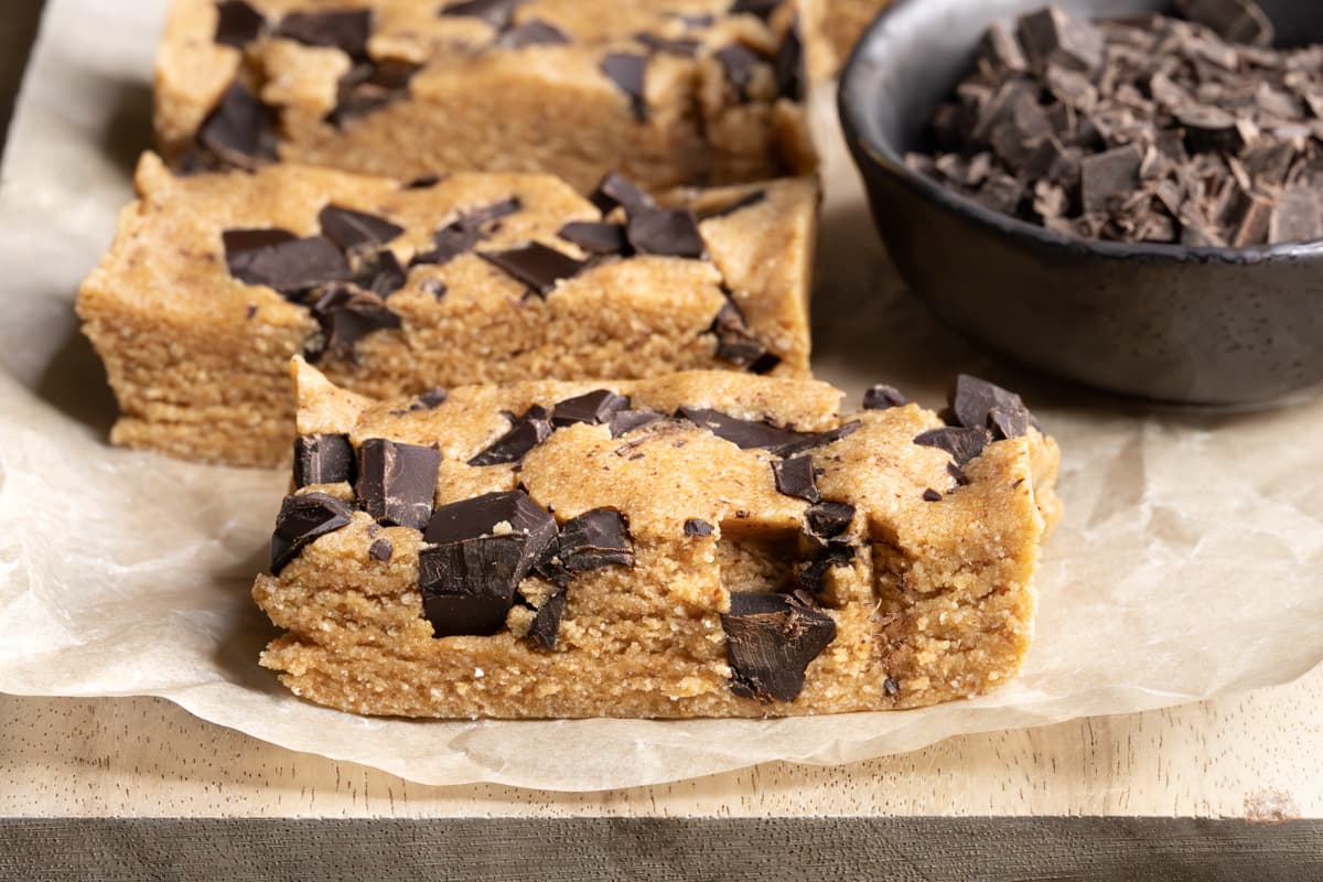 Protein bars with chunks of dark chocolate on a wooden board