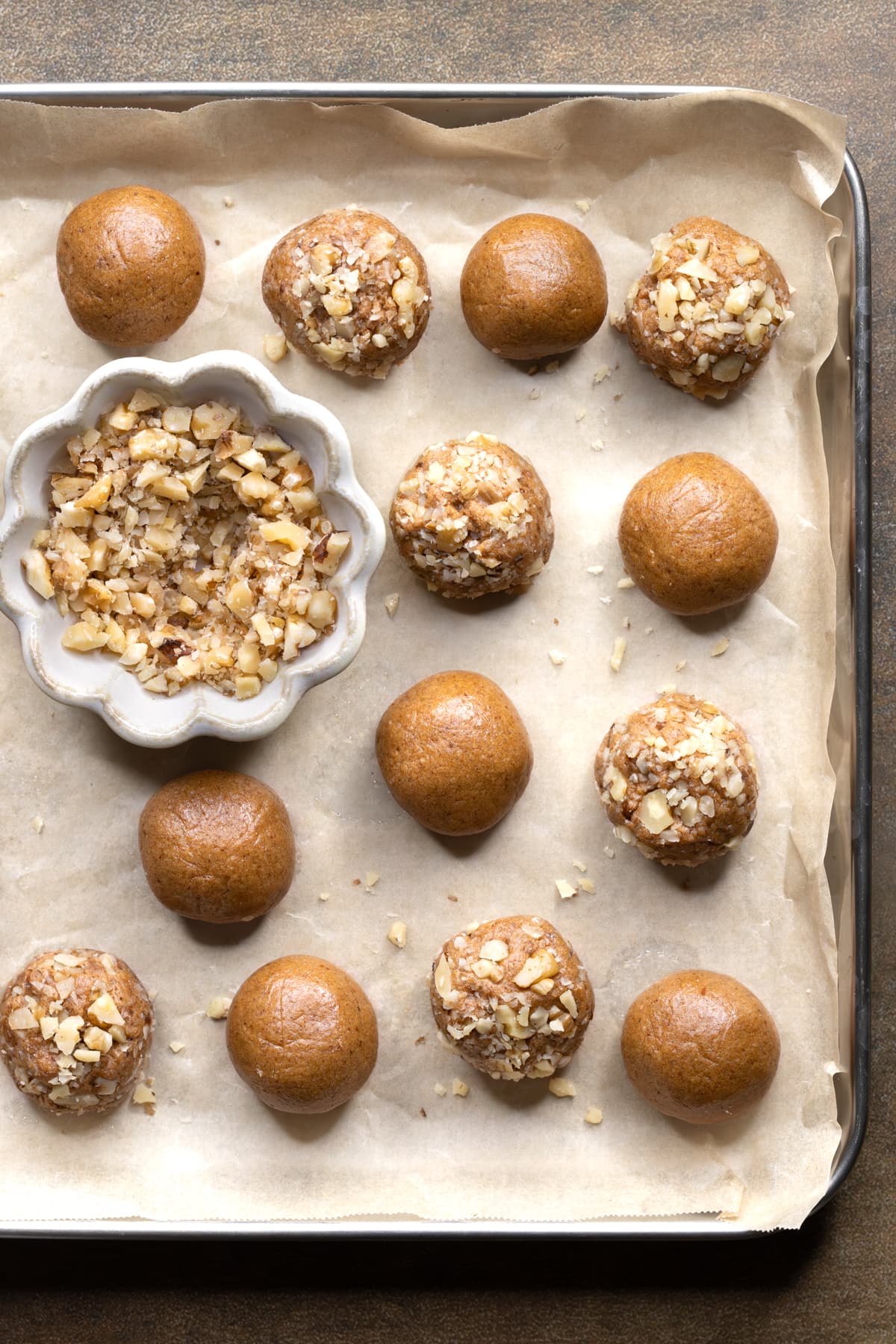 Coffee whey protein balls with cashew butter rolled in nuts on a baking tray