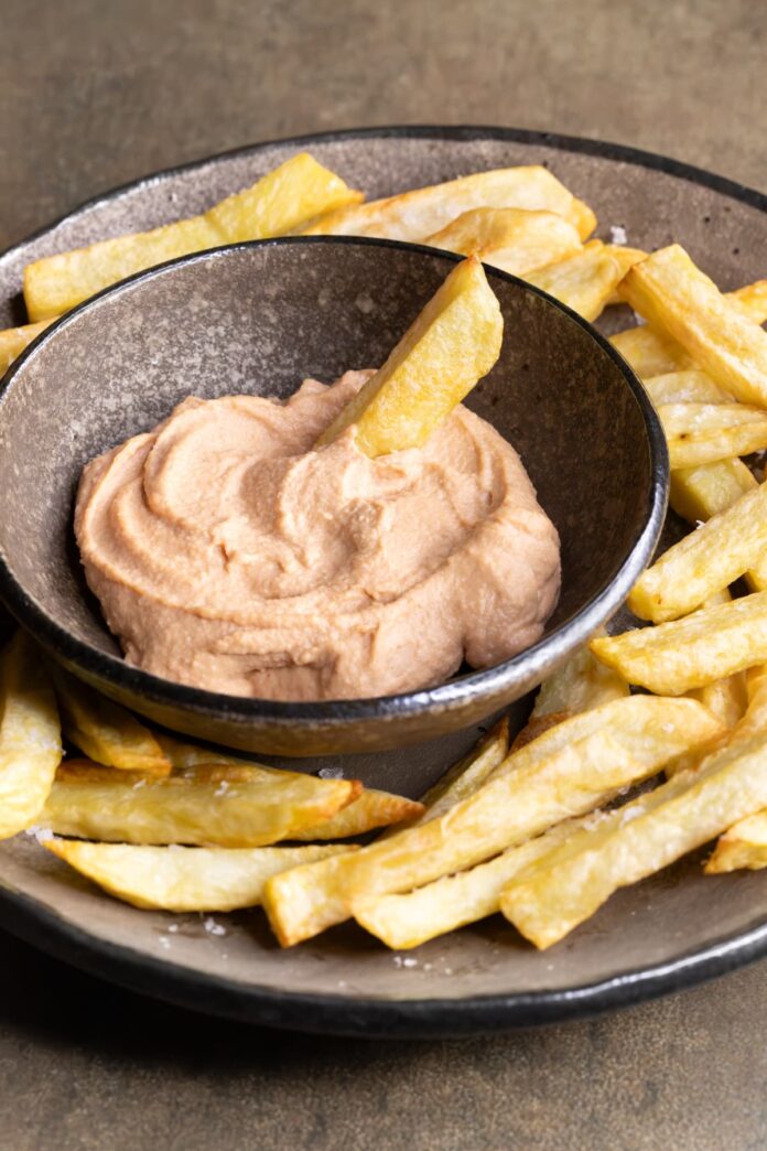 Healthy homemade vegan burger sauce served in a bowl with baked potato chips