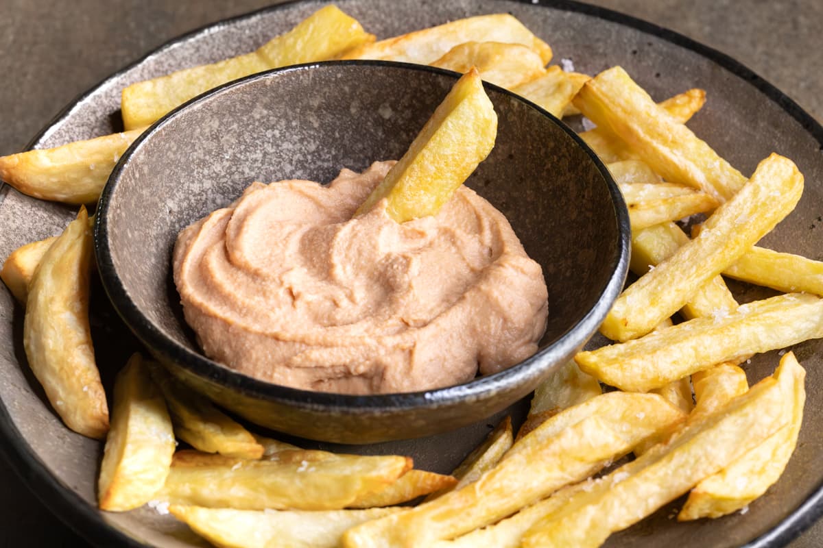 Gluten-free homemade vegan burger sauce in a bowl with with oven-baked French fries