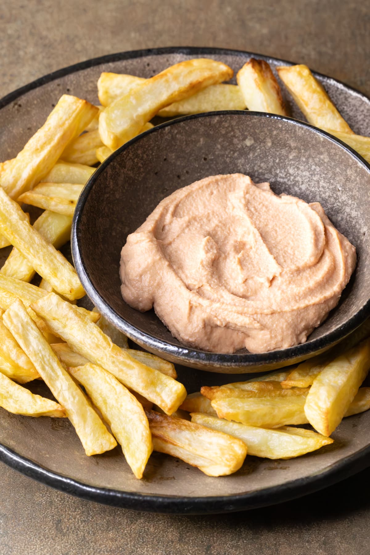 Easy homemade vegan burger sauce in a bowl on a plate with potato chips