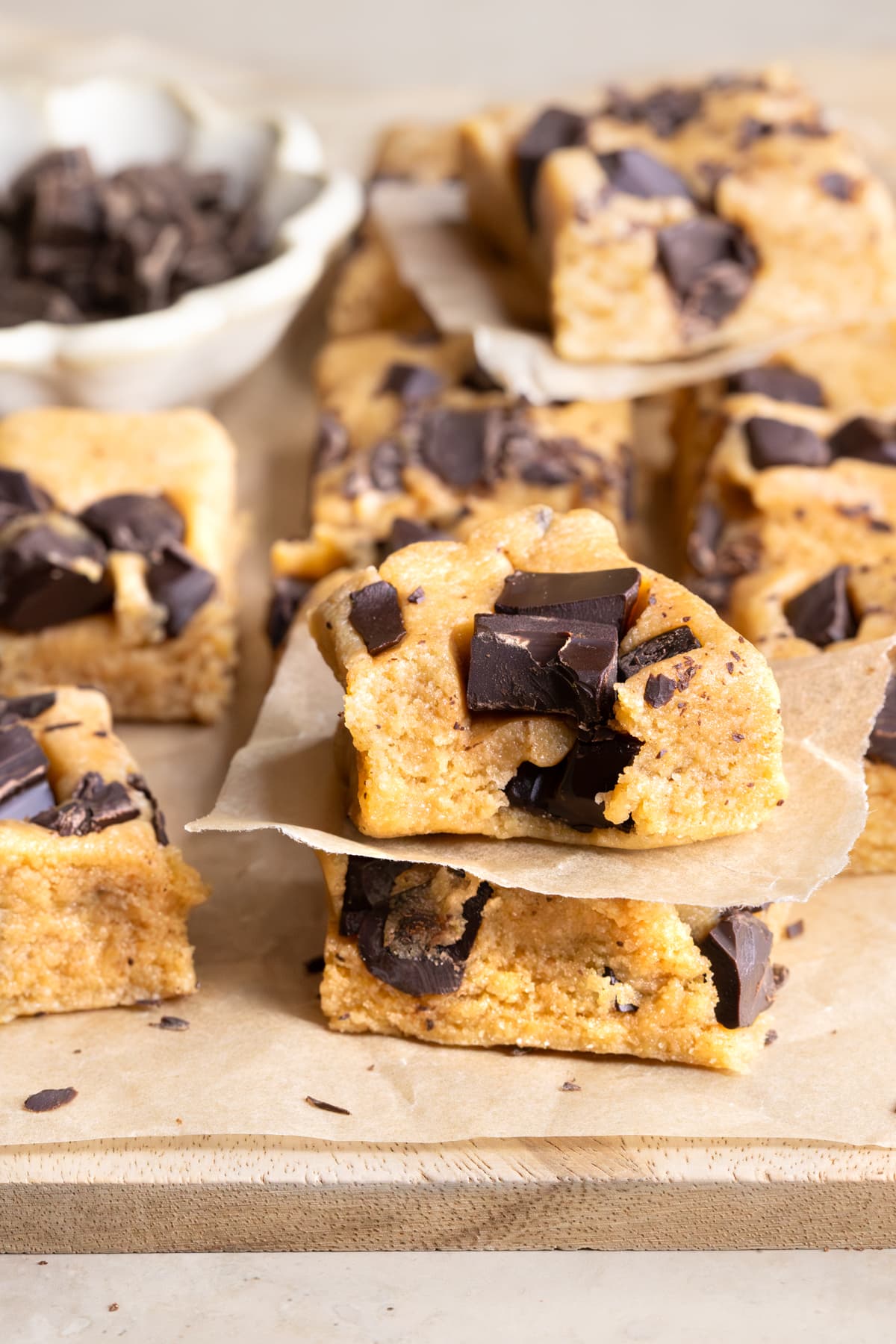 Choc chip cookie dough protein bars with collagen powder arranged on a wooden board