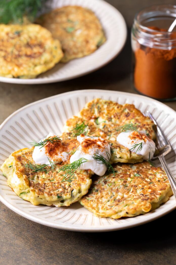 Healthy gluten-free zucchini fritters with feta served with yogurt and paprika