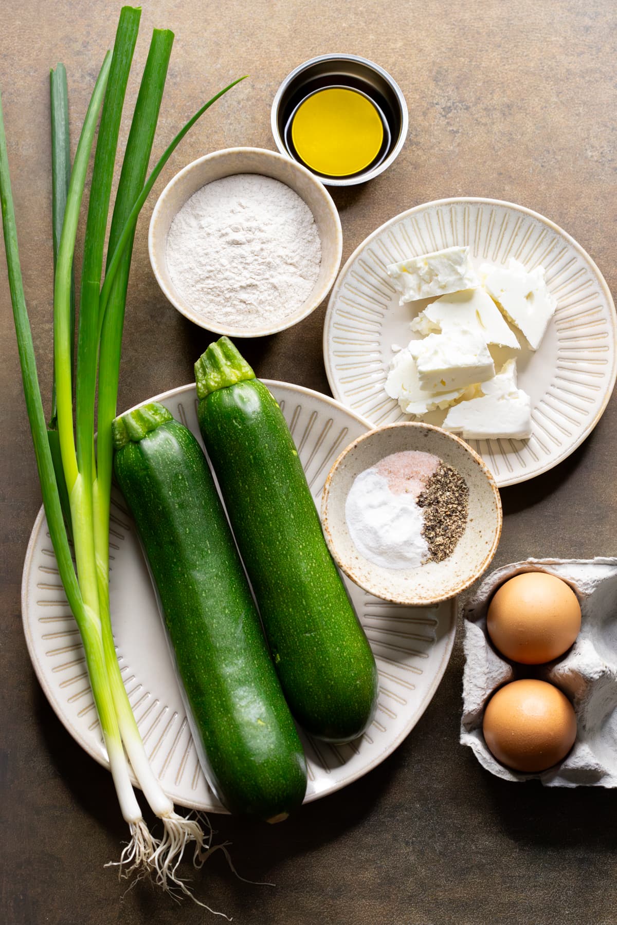 Ingredients for gluten-free zucchini fritters with feta laid out on a table