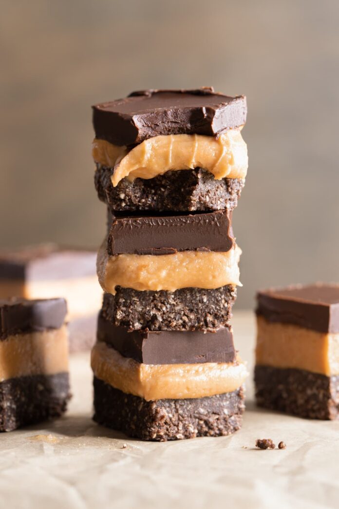 Stacked pieces of easy no-bake vegan slice with a chocolate base, caramel filling and chocolate topping