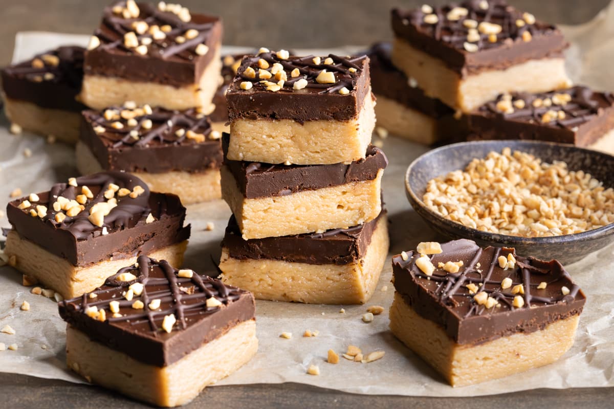 Gluten-free four ingredient vegan peanut butter bars topped with chocolate and crushed peanuts