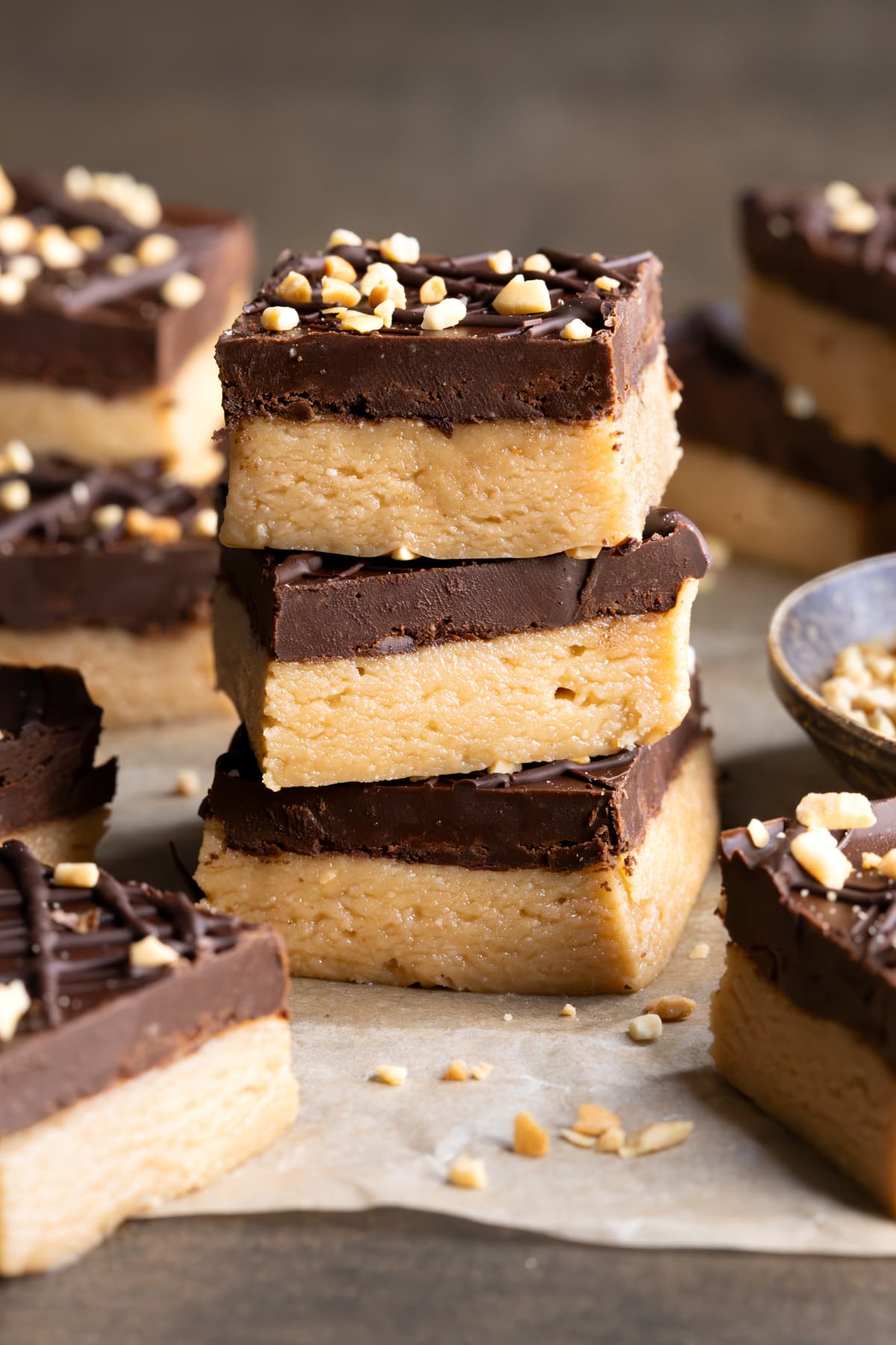 Healthy four ingredient vegan peanut butter bars stacked on a sheet of baking paper