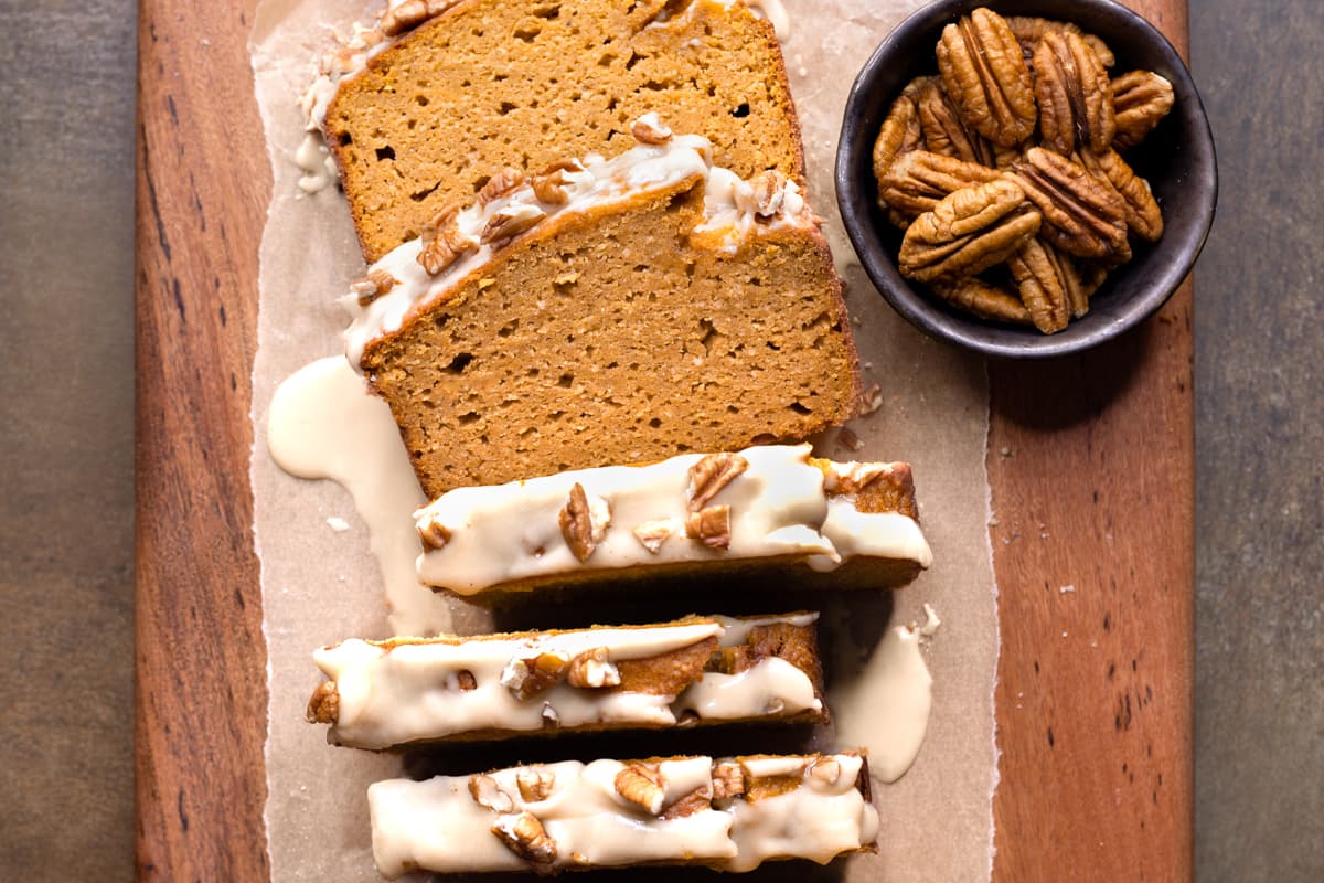 Slices of gluten-free pumpkin bread with maple glaze and pecan nuts