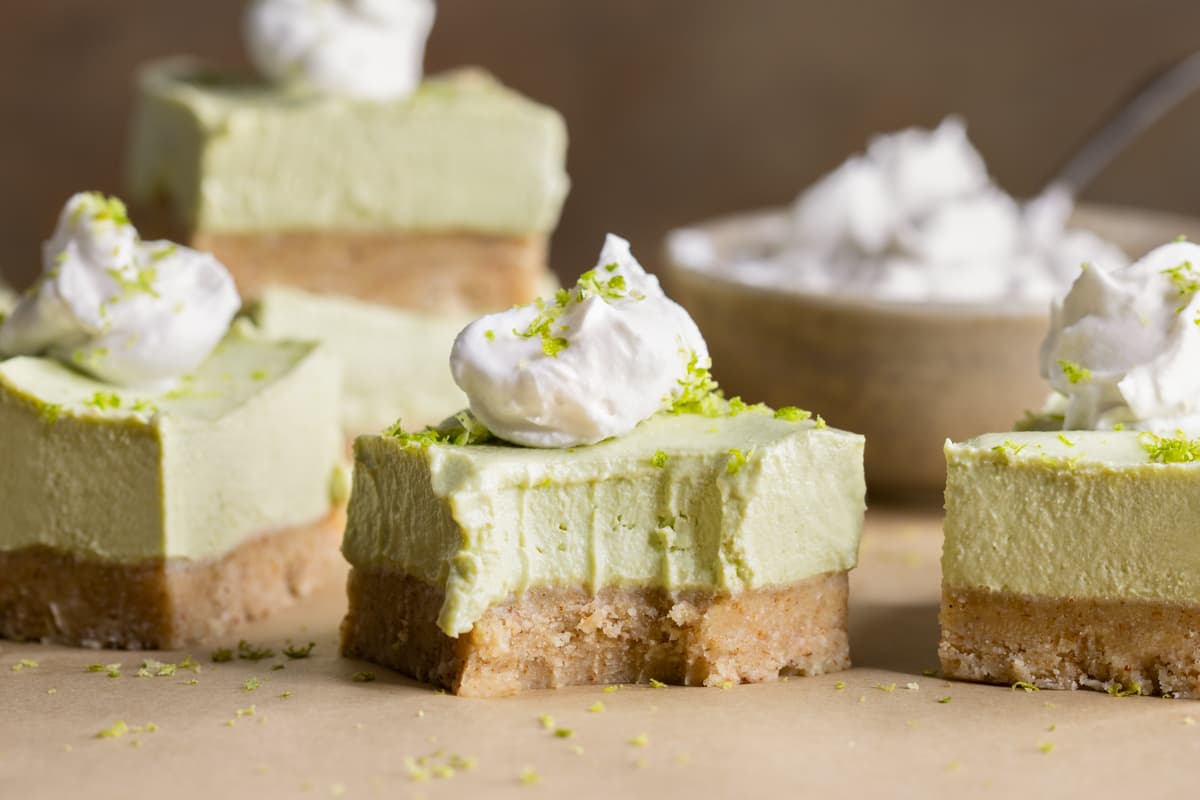 Vegan lime cheesecake bars with a bite taken out of one bar