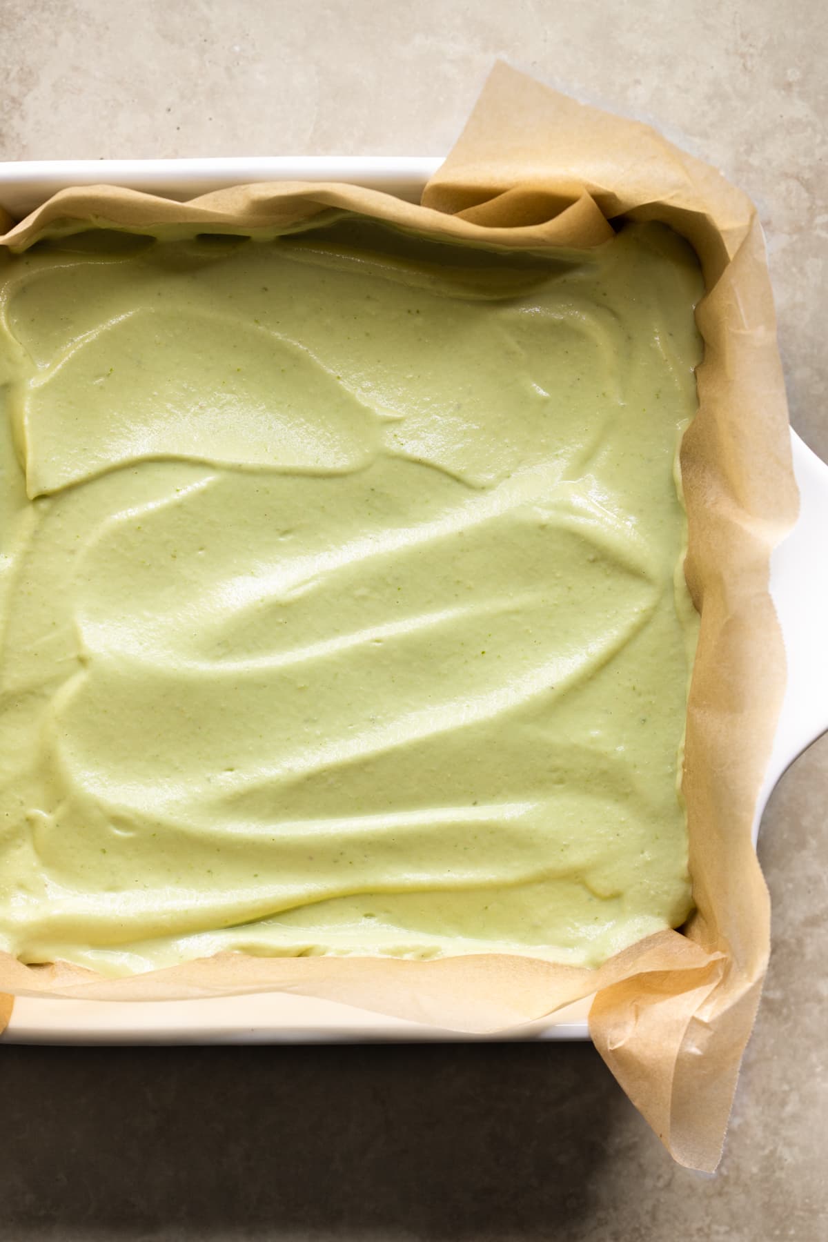 No-bake vegan lime cheesecake in a square dish lined with baking paper