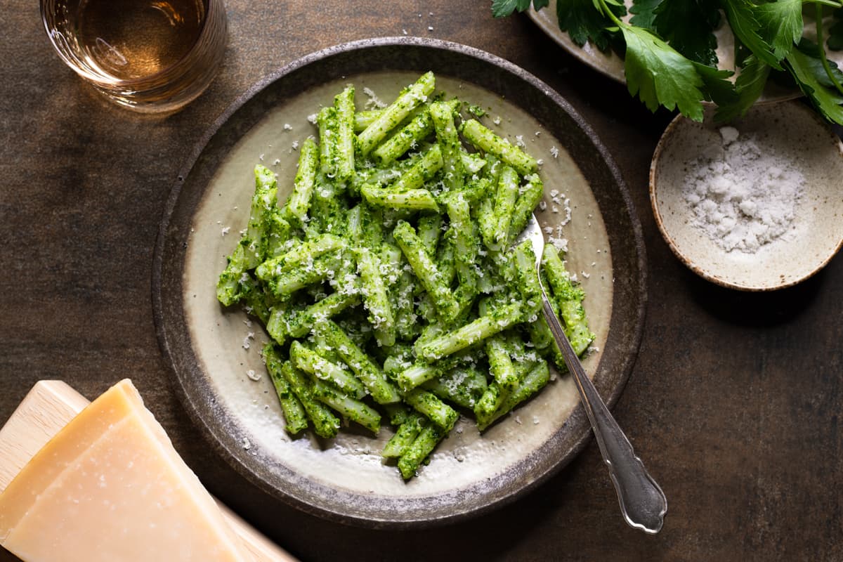 Easy parsley pesto pasta with cashew nuts served on a plate with a fork