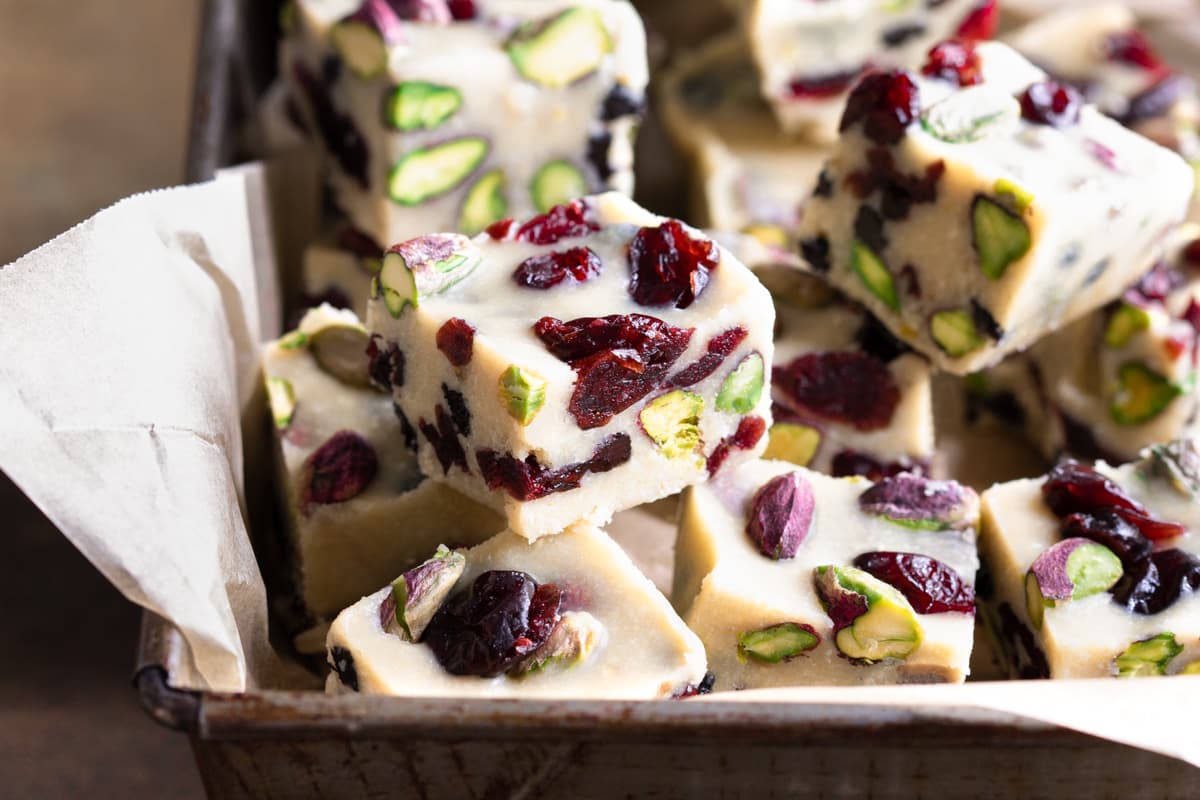 Squares of vegan white christmas slice arranged in a tin