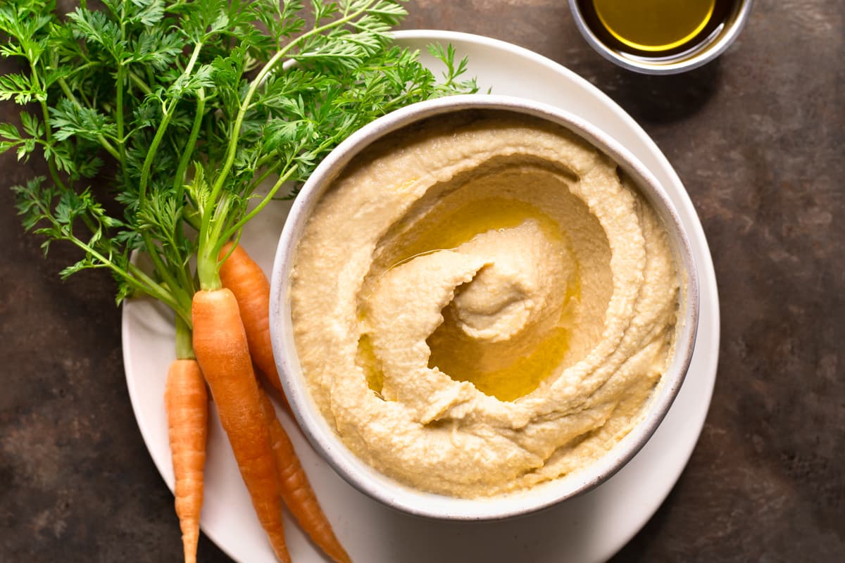 Hummus with no lemon or garlic served with a bunch of raw carrots