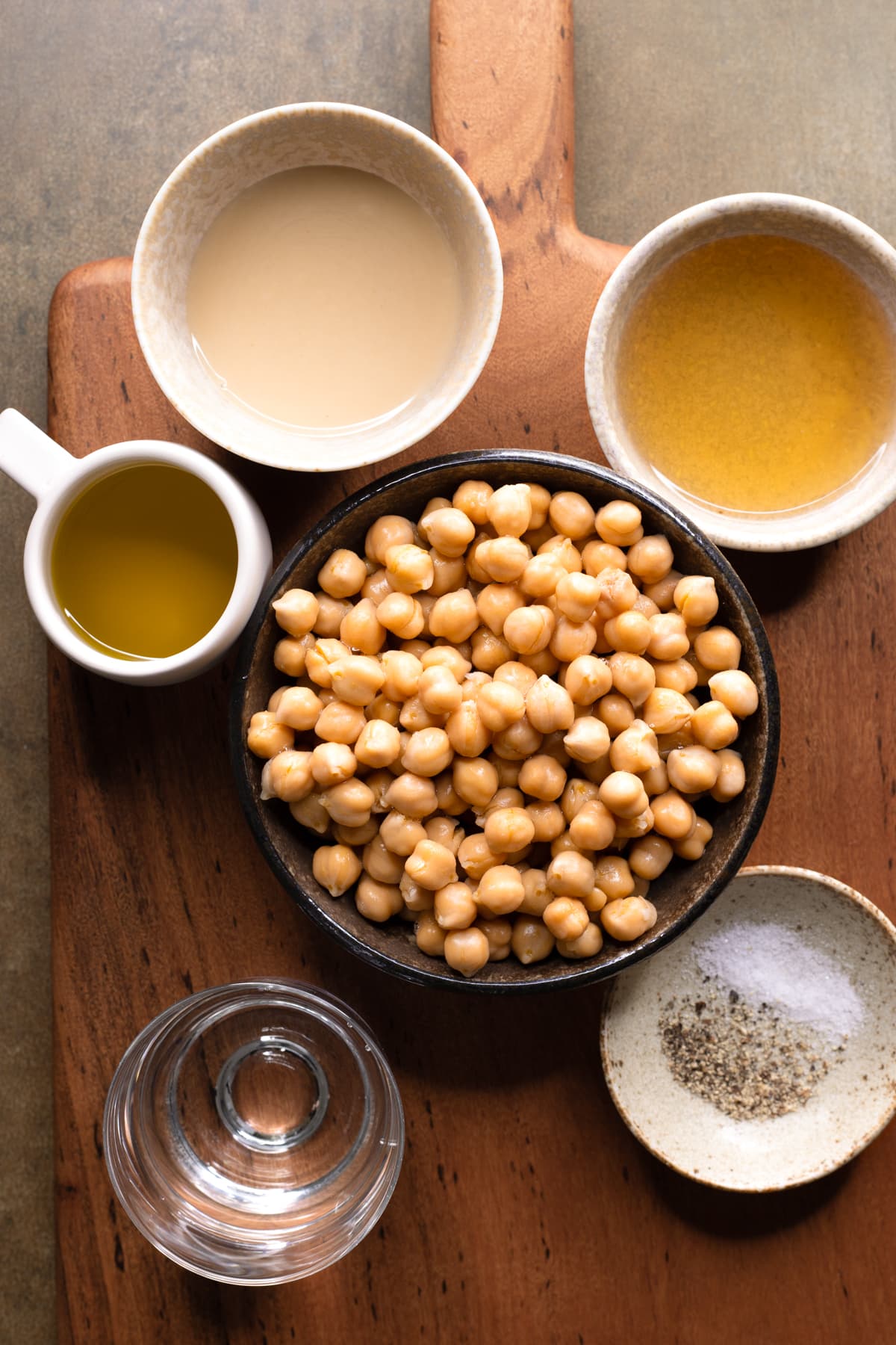 Ingredients for hummus without lemon and garlic in bowls on a wooden board