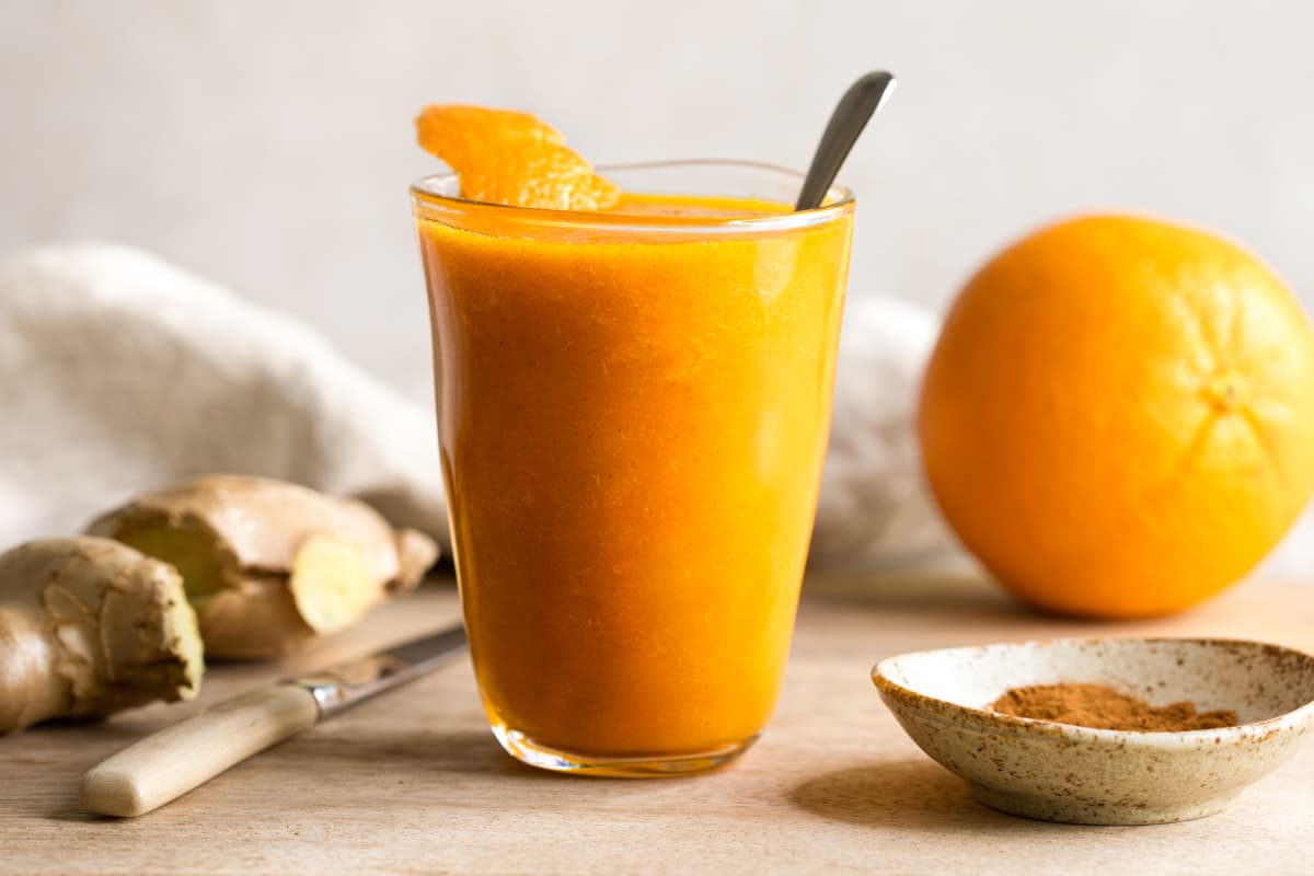 Orange ginger carrot smoothie garnished with orange peel