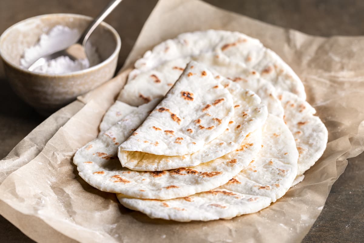 Flatbreads stacked on top of each other on a sheet of baking paper