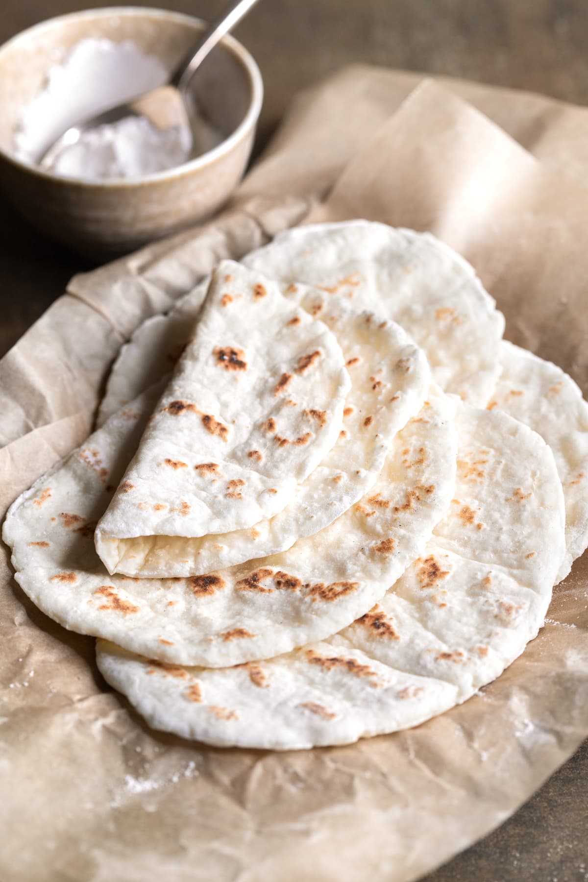 Flatbread stacked on a sheet of baking paper with one piece folded over