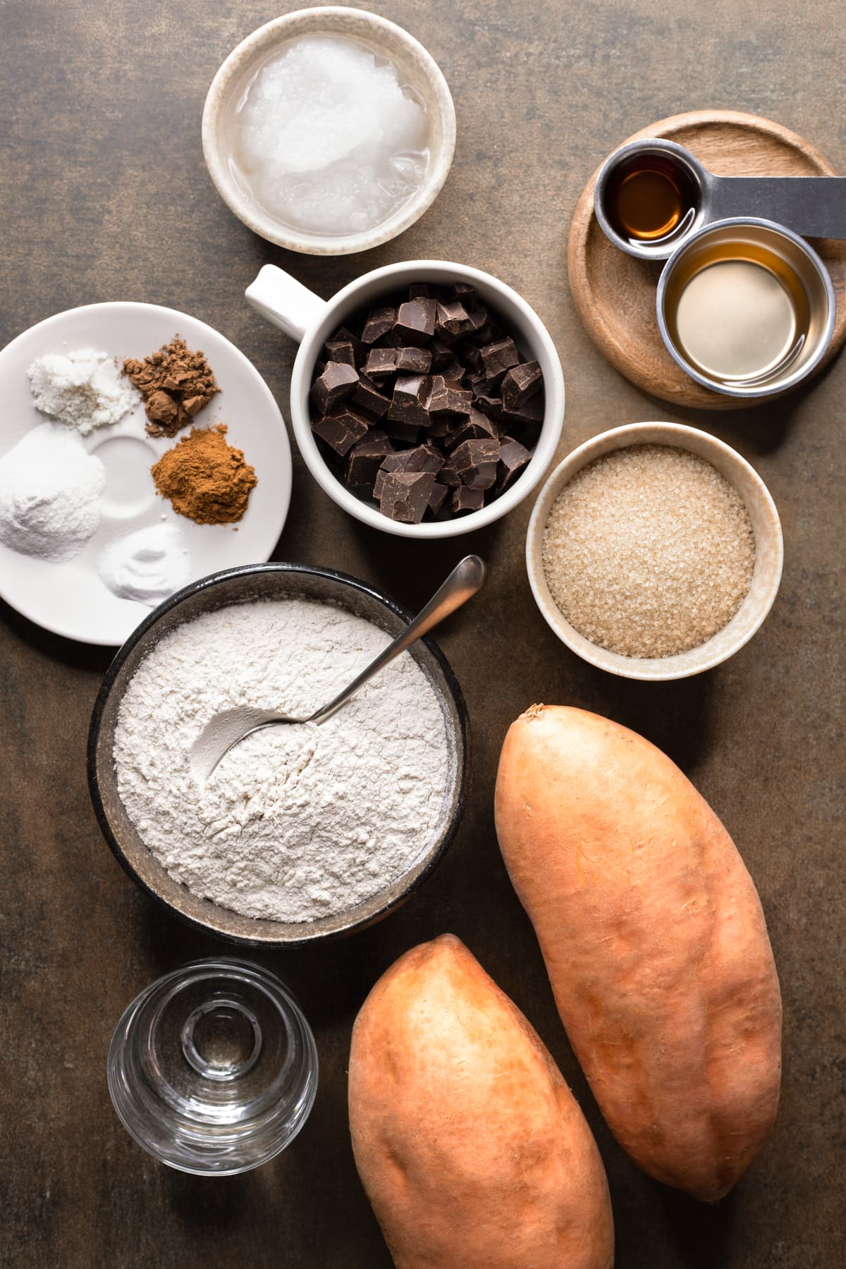 Ingredients for vegan sweet potato bread set out in cups and bowls