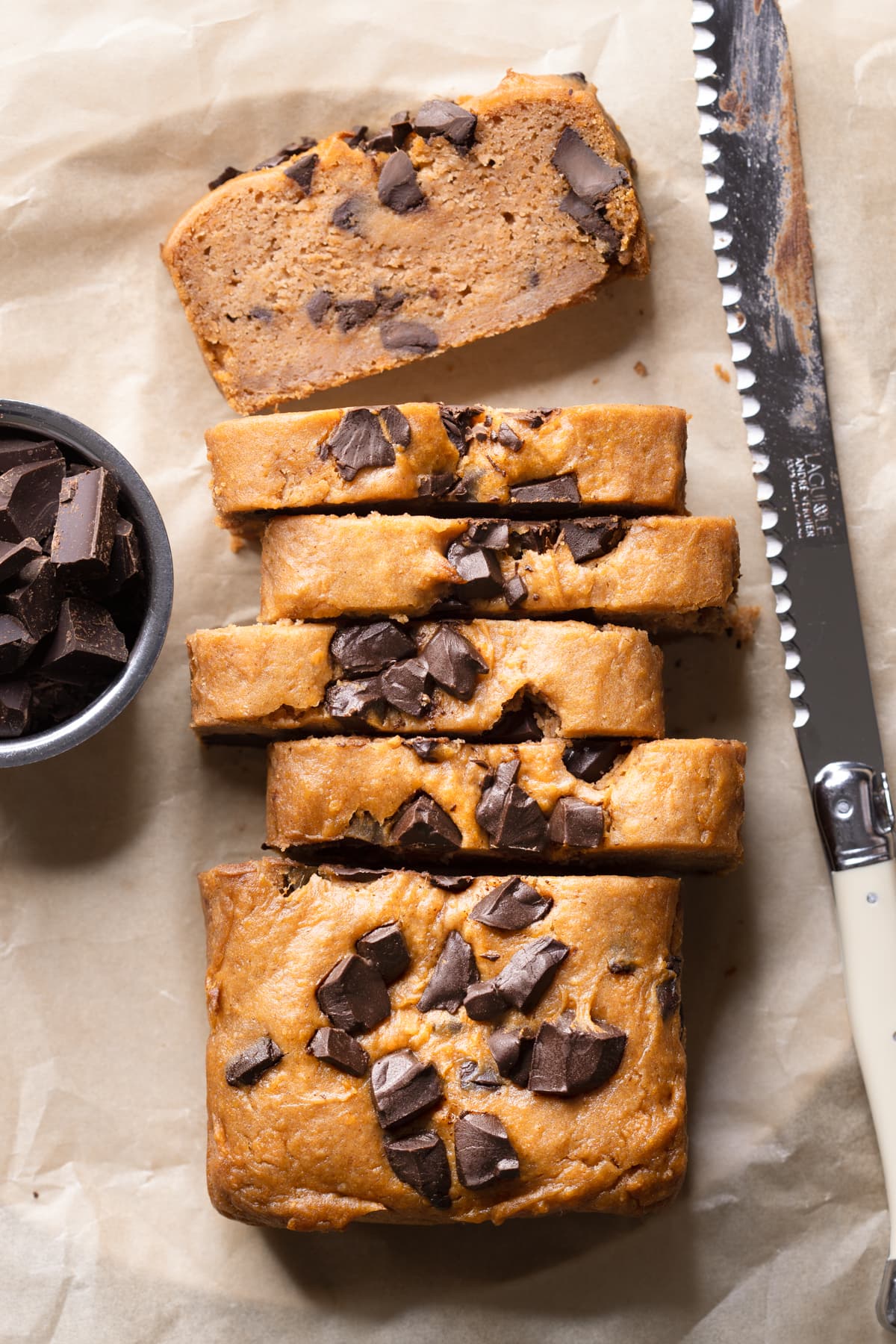 Slices of vegan chocolate chip sweet potato bread on a sheet of baking paper