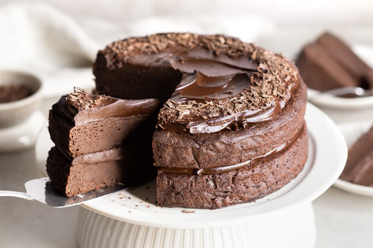 A slice of chocolate cake being served with a cake server