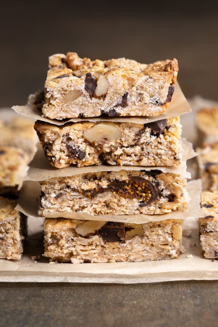 A stack of baked oatmeal breakfast bars with chocolate chips, nuts and dried figs