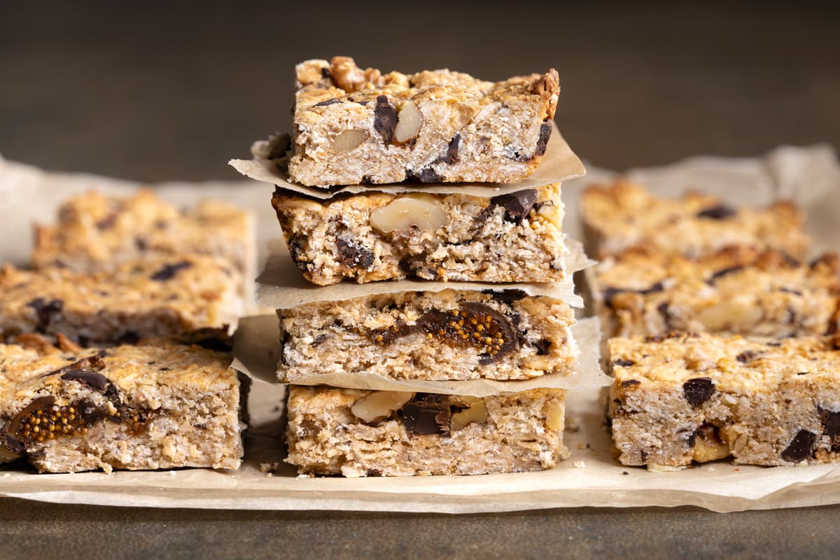 A stack of baked oatmeal breakfast bars separated with sheets of baking paper