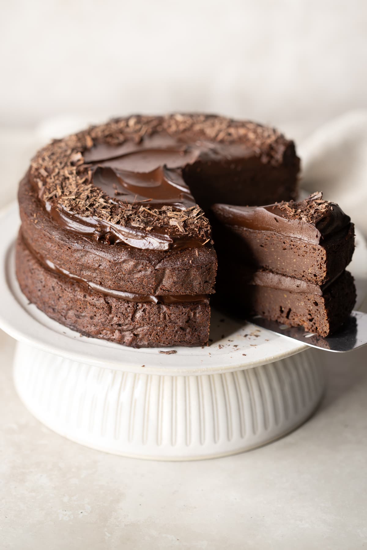 Double layer frosted chocolate cake with a slice being served