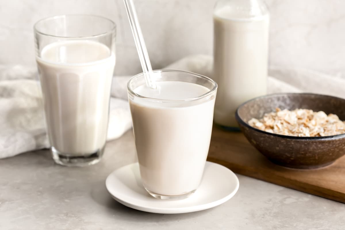 Oat milk served in a glass with a straw