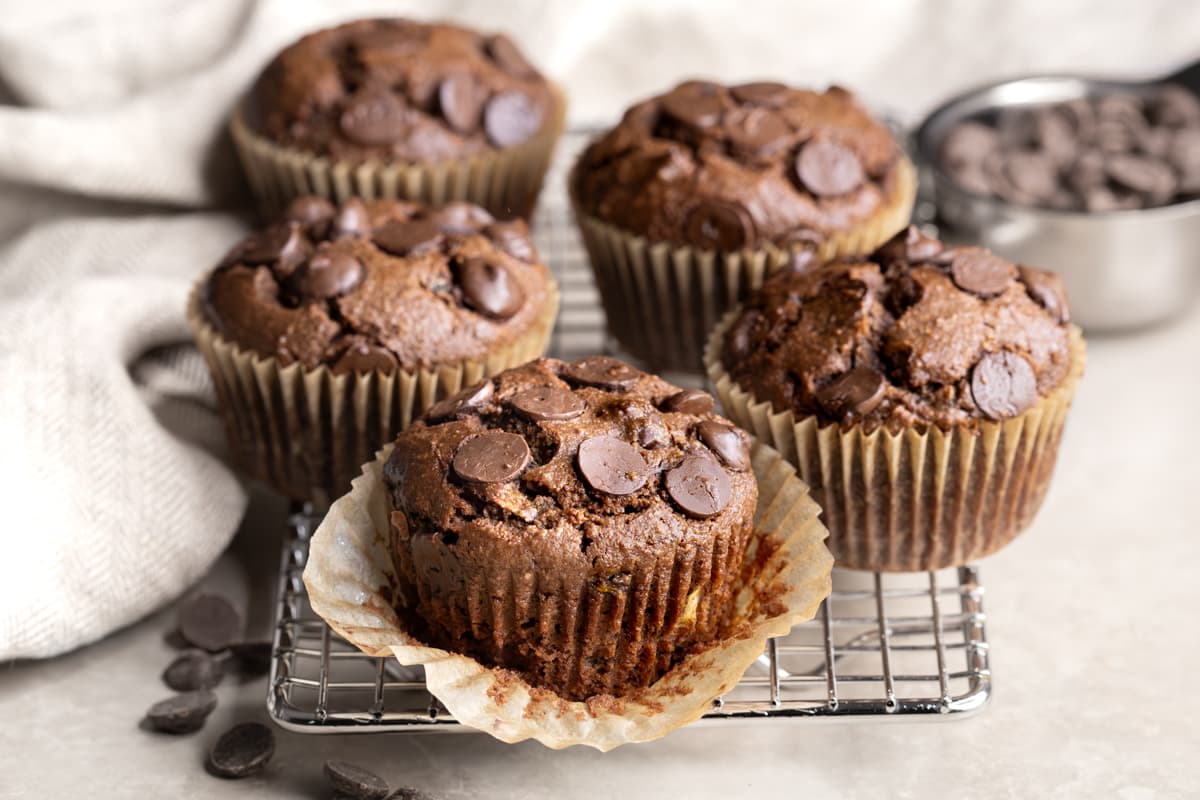 Chocolate chip muffins in paper cases on a cooling rack