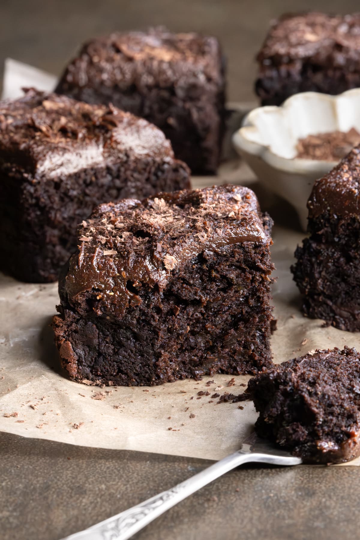 Frosted zucchini brownies with a bite cut from one piece