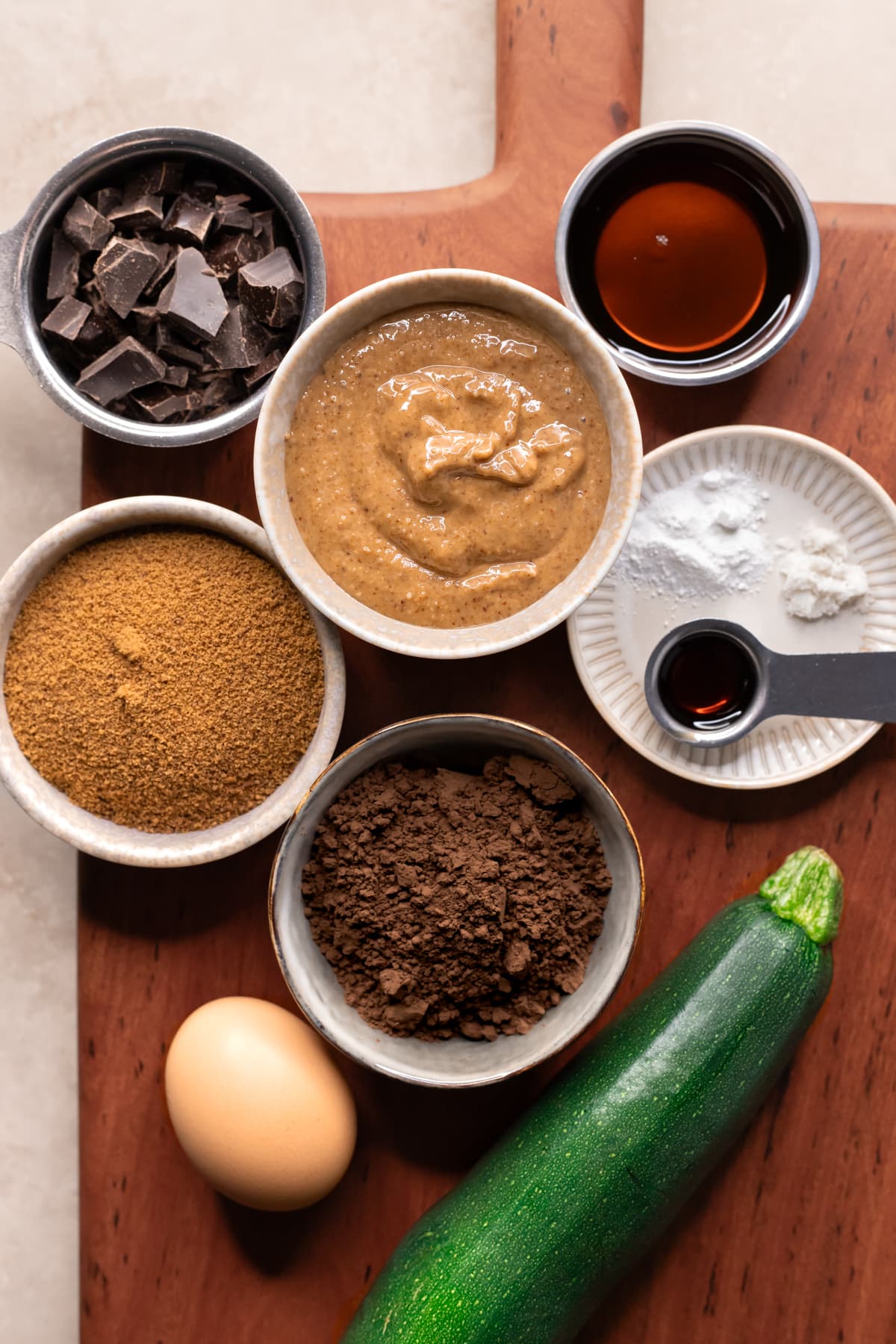 Ingredients for flourless zucchini brownies with chocolate frosting set out in bowls