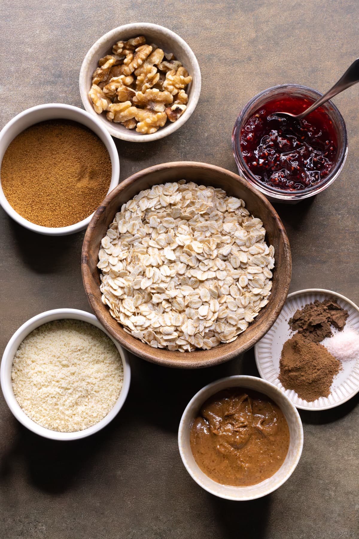 Ingredients for oatmeal linzer crumble bars set out in bowls