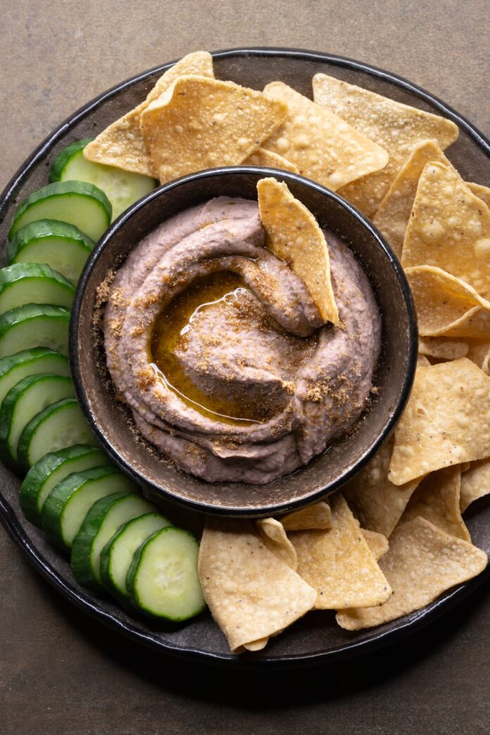 Vegan black bean dip served with tortilla chips and cucumber slices