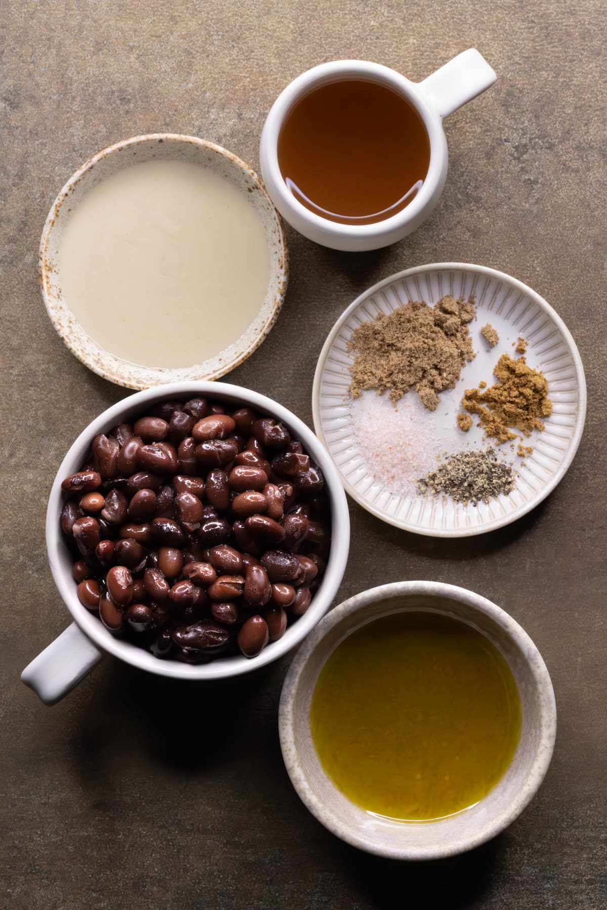 Ingredients for vegan black bean dip set out in bowls and cups