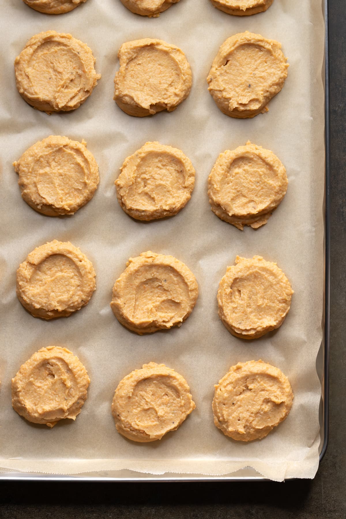 Batter for chickpea fritters shaped into discs on a baking sheet